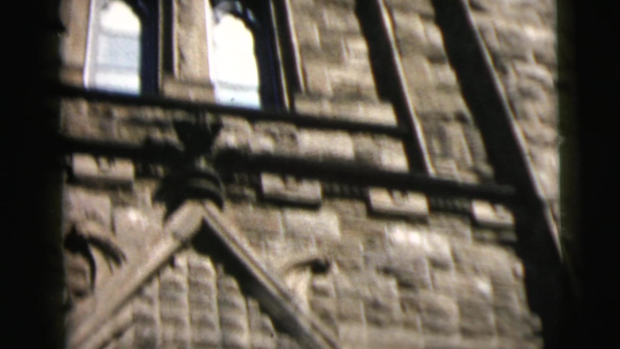 Close view of stone tower details seen beside a dark window frame.