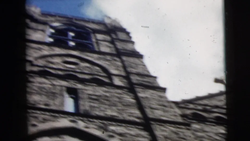 1962 Camden, New Jersey 8mm frame showing the tower face, roofline, and foreground window-like divider during a handheld tilt.