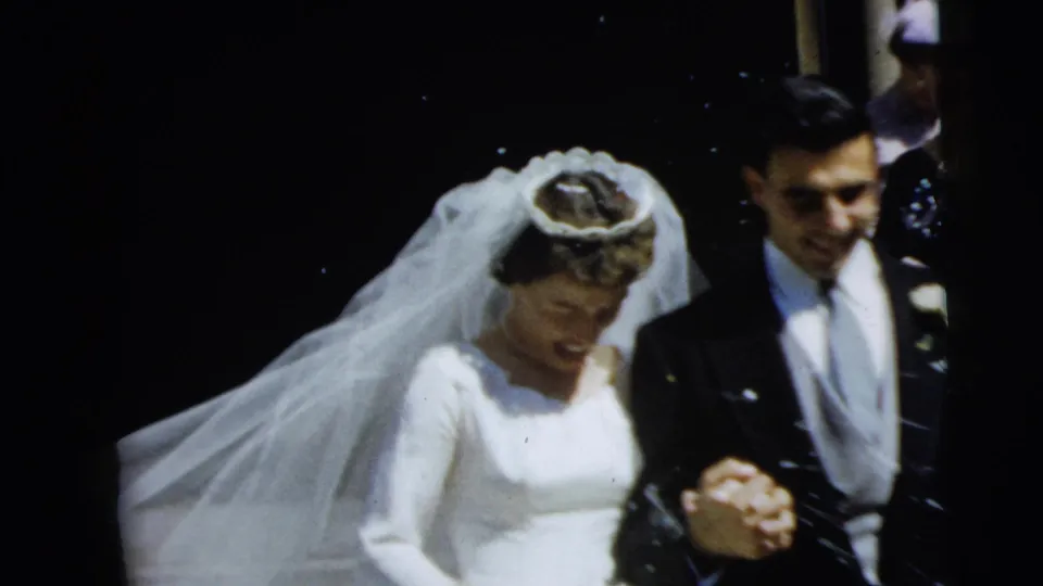 Bride and groom continue their Camden church wedding exit with veil trailing and confetti visible.