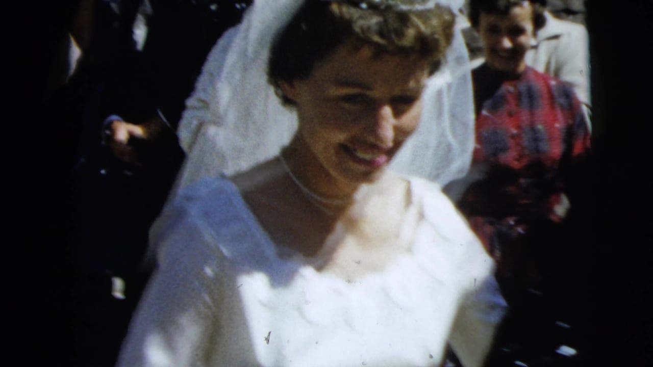 A smiling bride in a white gown and veil moves through a wedding crowd in Camden, New Jersey, according to the clip metadata.