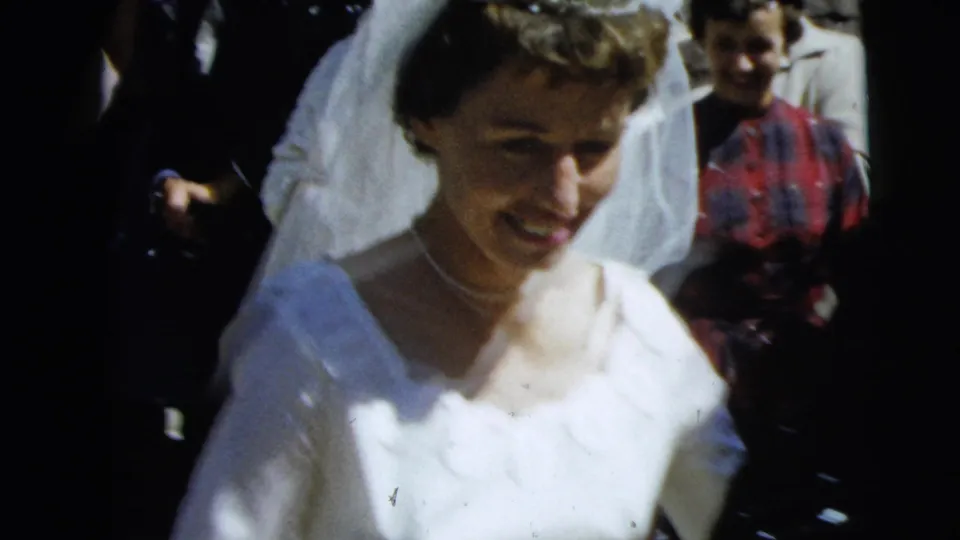 A smiling bride in a white gown and veil moves through a wedding crowd in Camden, New Jersey, according to the clip metadata.