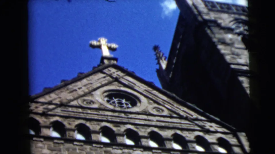 Church exterior in Camden, New Jersey, with a cross above the roofline, seen in 1962 wedding home-movie footage.