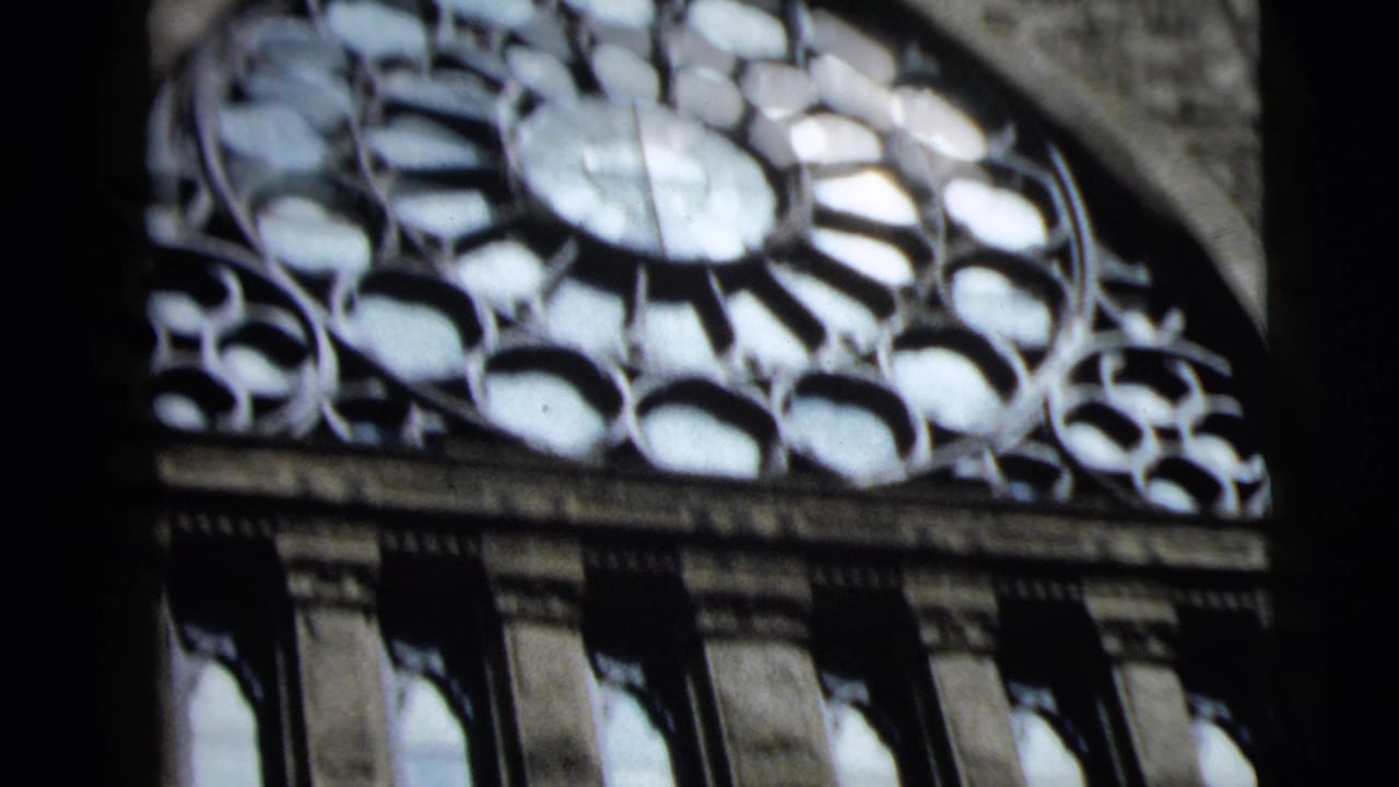 Camden church facade detail with a large rose window, leaded glass pattern, stone trim, and vertical arched windows below.