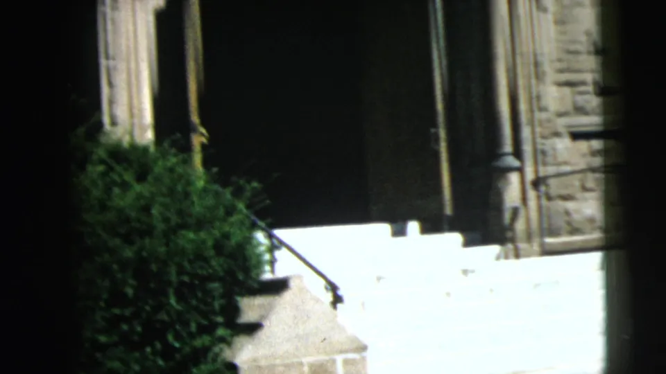 Church entrance in Camden, showing bright stone steps, a dark recessed doorway, side columns, railing, and shrubbery at the base.