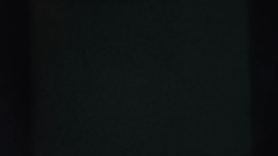 A dark 8mm transition frame shows faint color and shadow, with no clearly identifiable subject visible.
