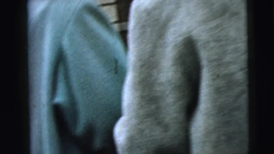 In metadata-supported 1962 Camden, New Jersey footage, two women in heavy blue and gray coats walk away from the camera near brick residential buildings.