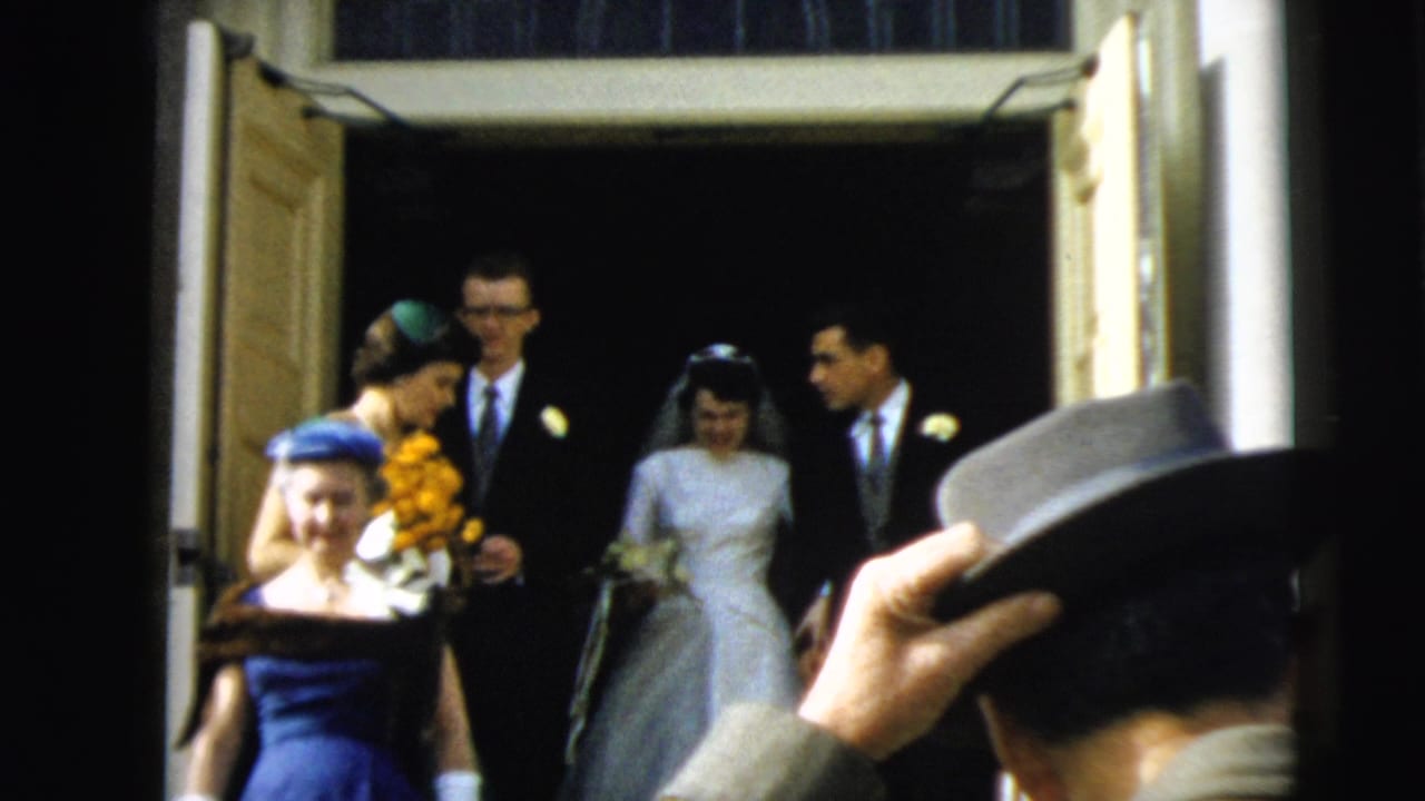Bride and groom exit a church doorway with attendants and guests nearby.