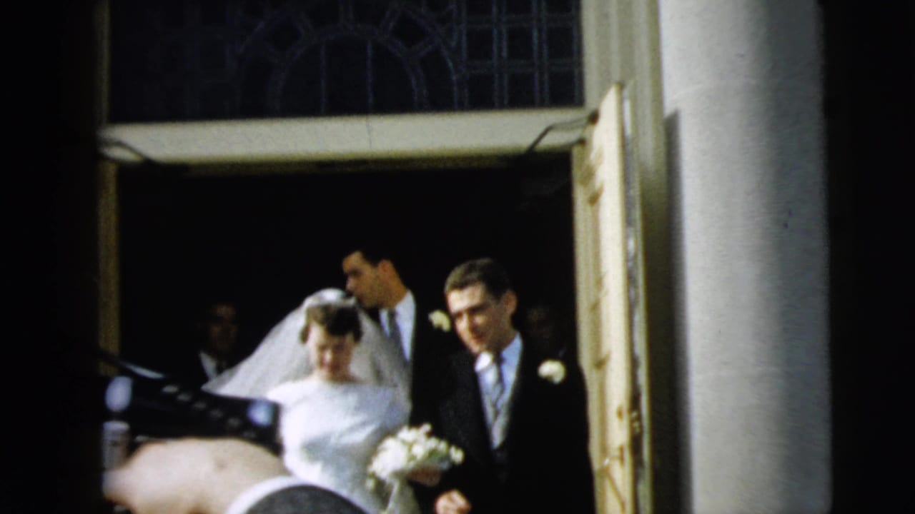 The couple emerges from the church entrance in Camden, New Jersey, with the bride holding flowers and the groom at her side.