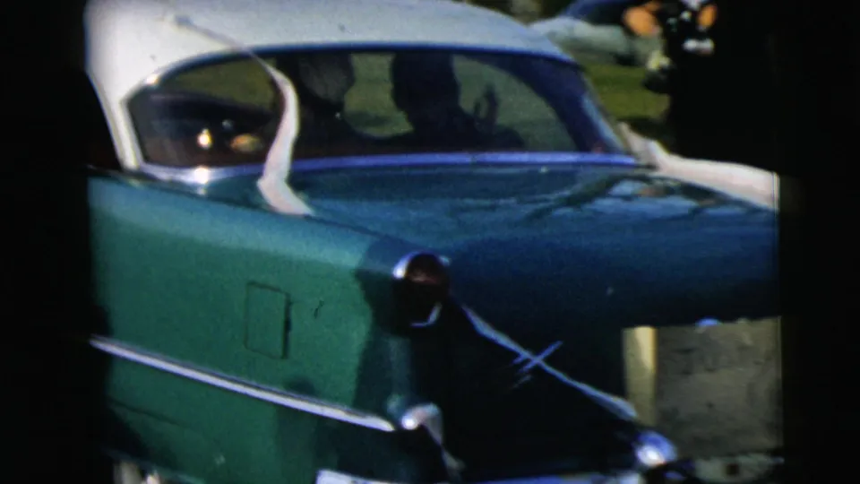 Close rear view of a green-and-white sedan with chrome trim, filmed from another vehicle in Camden, New Jersey, according to clip metadata.