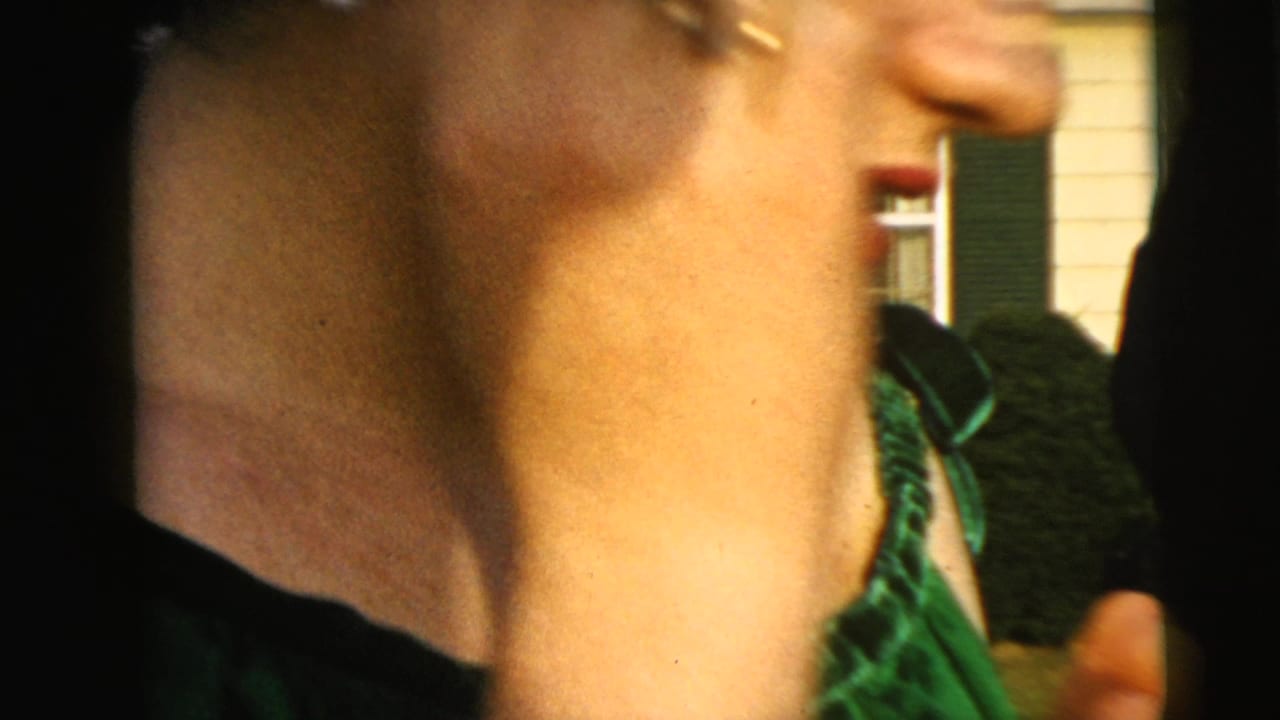 Close view of a woman's partial profile and shiny green dress outdoors.