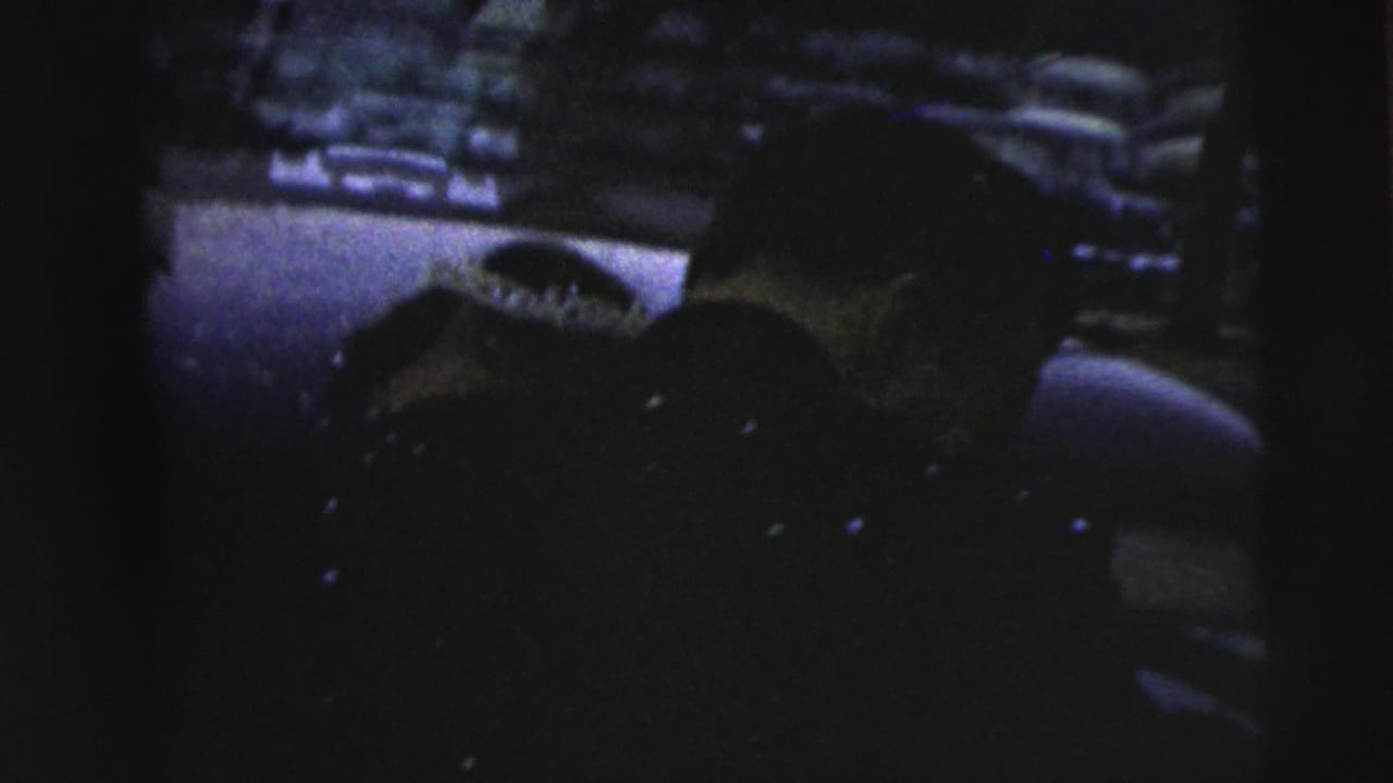 Dark close view of an adult handling a long gun outdoors.