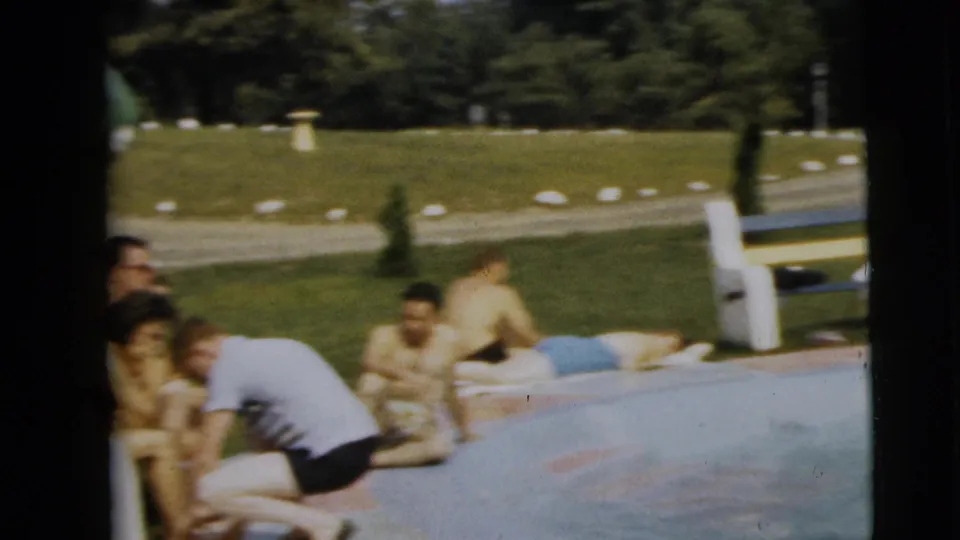 Poolside gathering in Camden, New Jersey, with several people in period swimwear sitting or reclining beside the water.