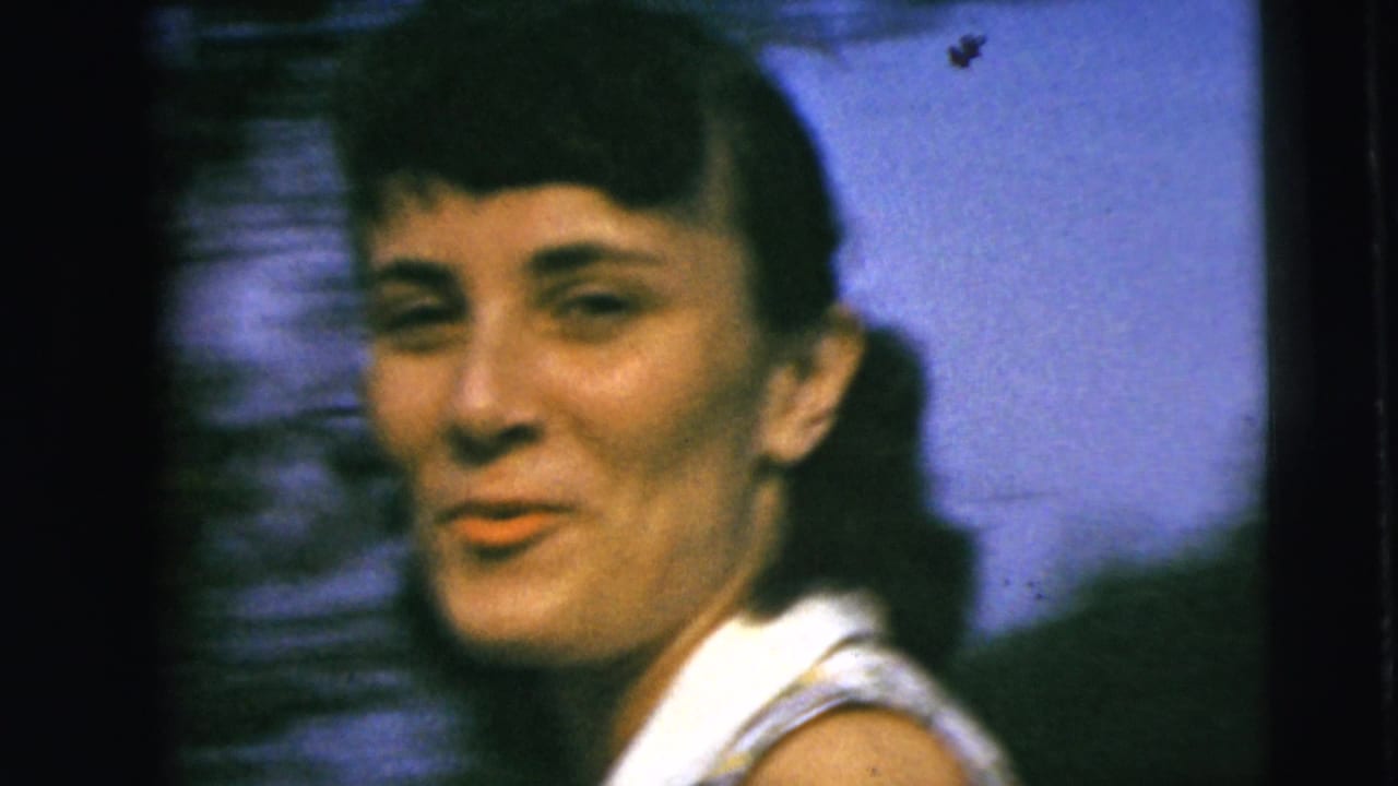 Close 1962 Camden frame of a young woman in a white sleeveless shirt turning toward the camera with trees behind her.
