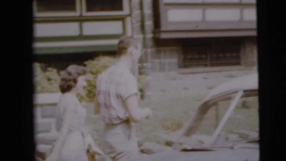 The couple walks toward a vintage parked car in the Camden residential scene.