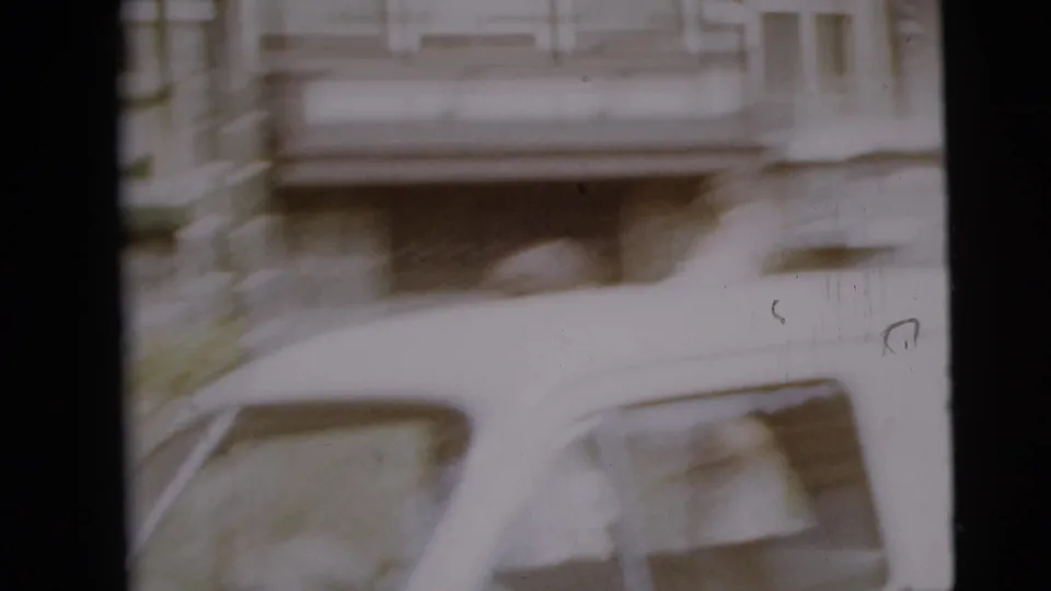 A motion-blurred frame shows a car close to the camera with house and yard details behind it.
