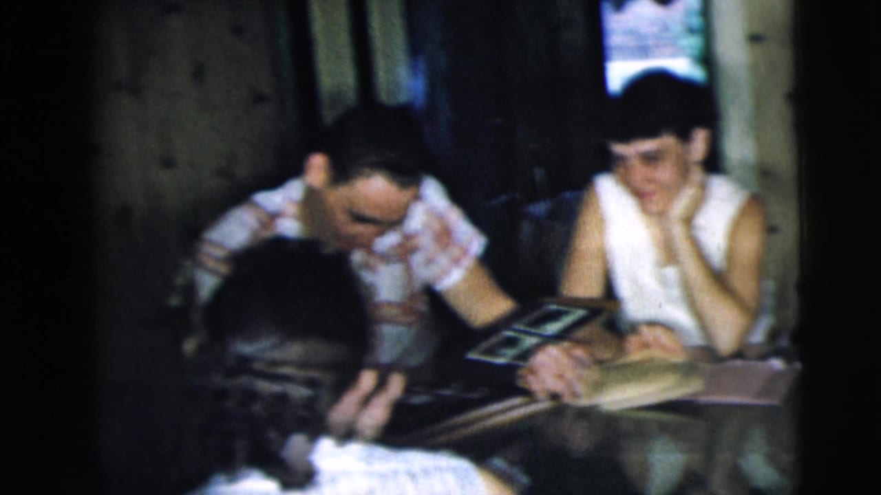 Adults in a Camden, New Jersey interior sit at a table with a photo album, smiling and leaning into the conversation.
