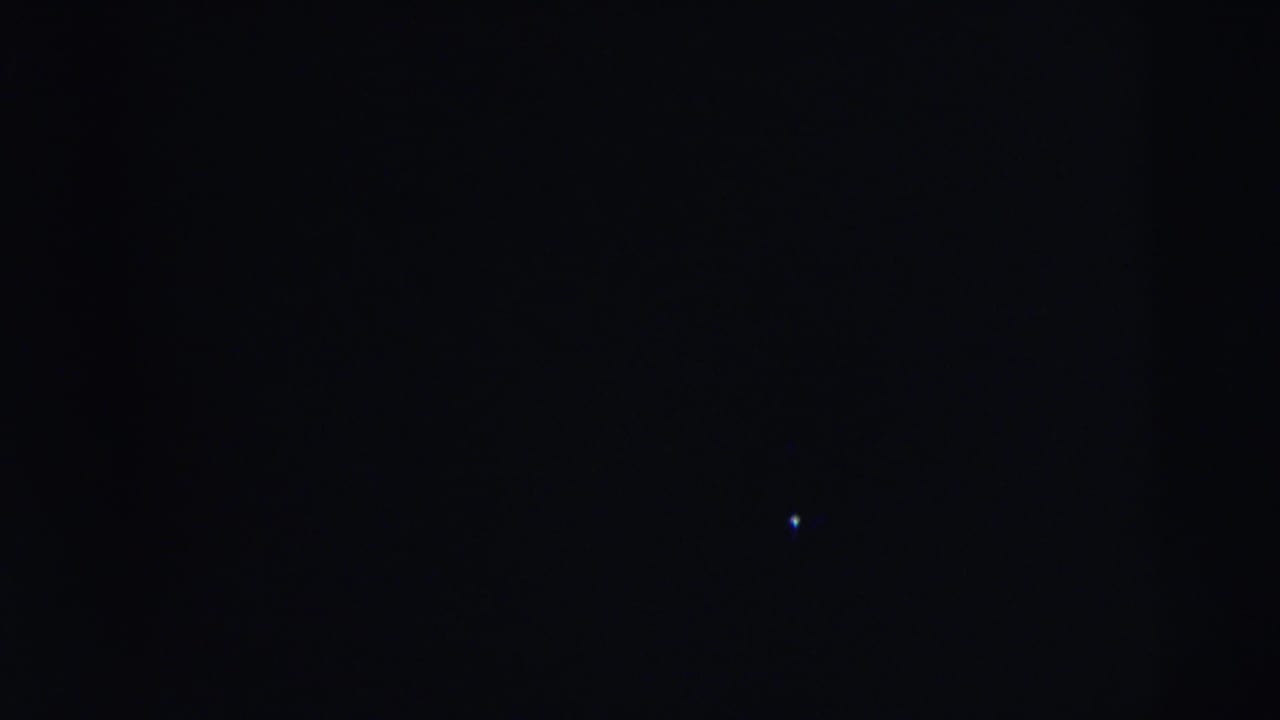 Dark, underexposed 8mm frame from the Camden 1962 clip with no identifiable people or setting visible.