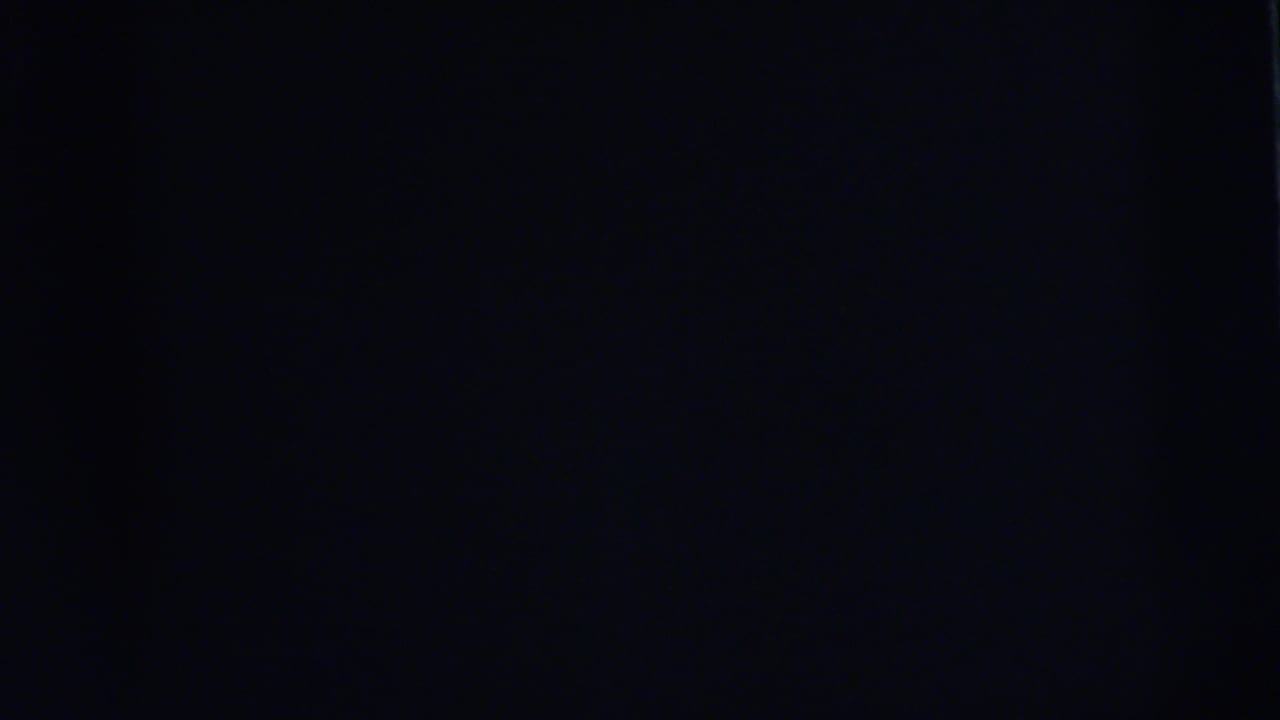 Underexposed 8mm frame in the 1962 Camden sequence, with only faint film texture visible.