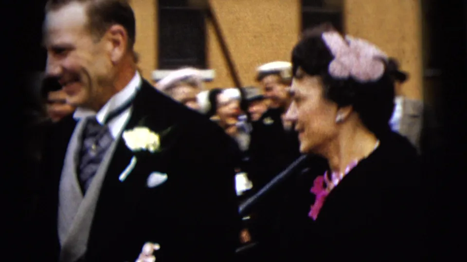 A closer 1962 Camden wedding view shows the couple passing the camera with guests and onlookers behind them.