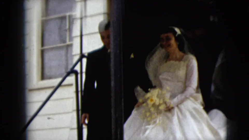 The bride appears in the church doorway in Camden, New Jersey, wearing a white gown and veil and holding a light-colored bouquet.