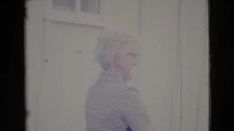 The woman appears to smile and speak outside a building in Cottonwood, Arizona, with pale siding behind her.