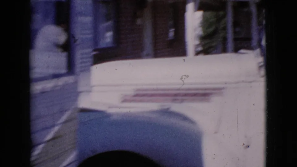 1964 Cottonwood, Arizona home-movie frame showing a white pickup truck moving past a residential porch area.