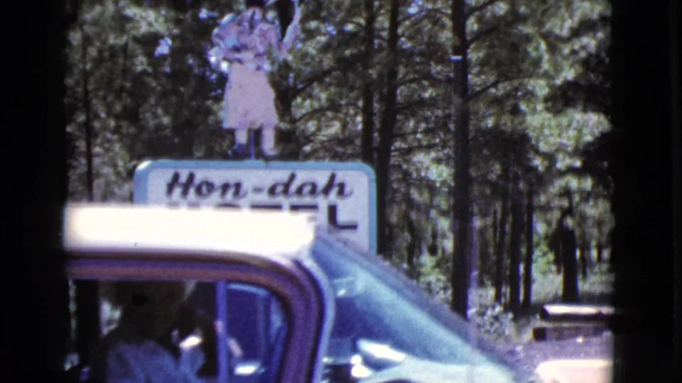 A purple-and-white car passes the Hon-dah Motel sign in 1964 Arizona home-movie footage.