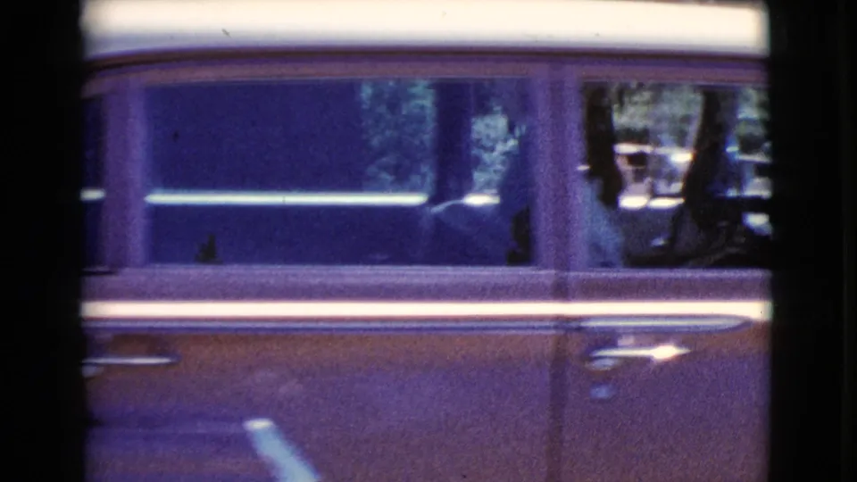 Close side view of a 1960s car with a passenger silhouette, filmed in Cottonwood, Arizona home-movie footage.