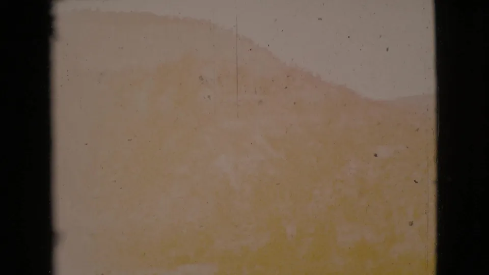 Faint Cottonwood, Arizona cliff or hillside form in a faded 8mm frame, with pale exposure, specks, and dark side borders.