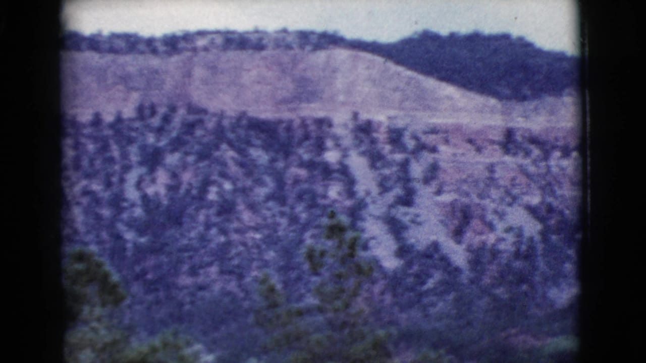 Distant rocky ridge with a tree-covered slope below.