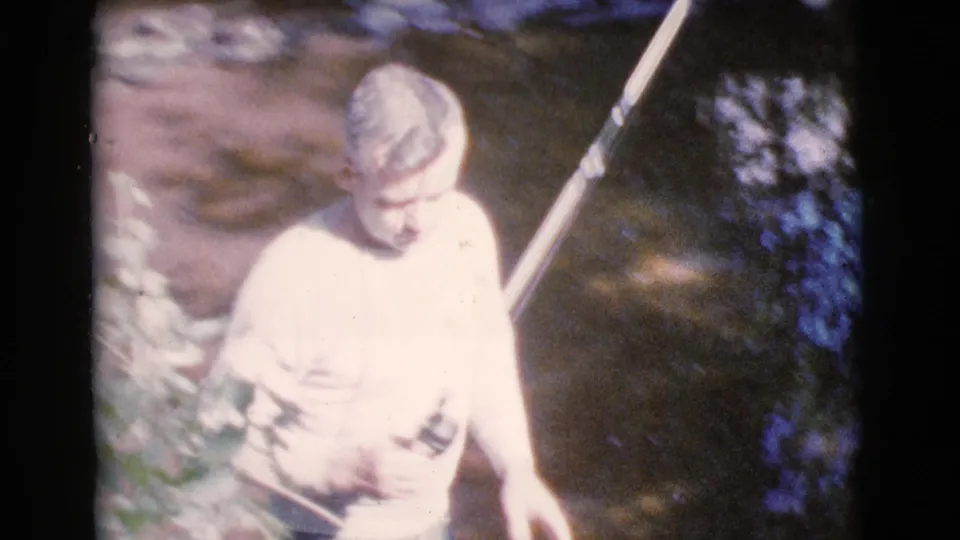 The 1964 Cottonwood, Arizona footage shows the male figure looking down near the stream, with his fishing rod angled behind him.