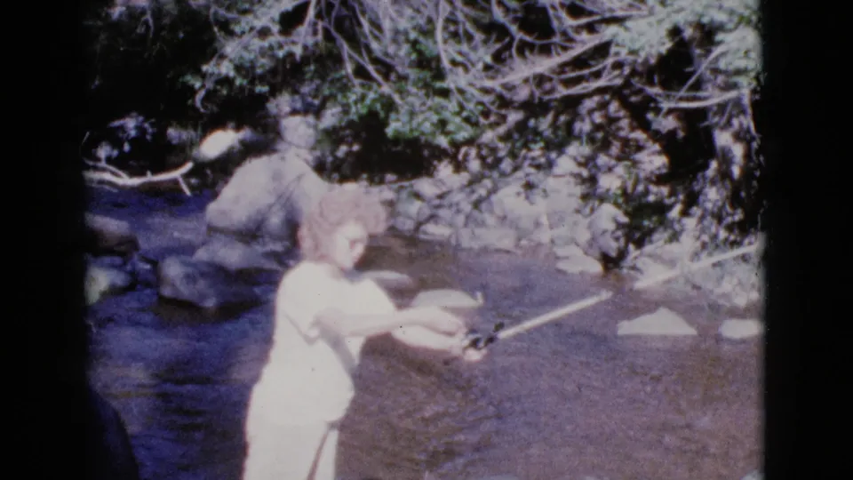 A young woman in a light dress extends the rod forward while casting in the Cottonwood, Arizona stream scene.
