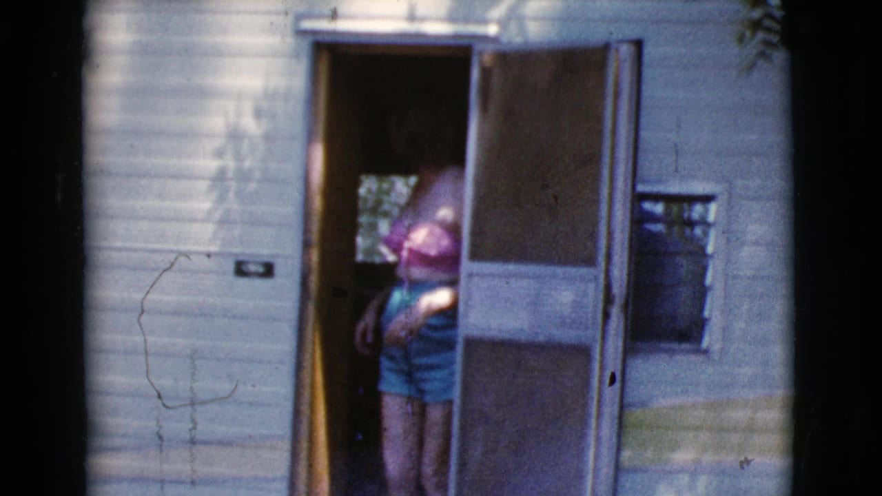 Woman in bright summer clothes emerging from a camper doorway.