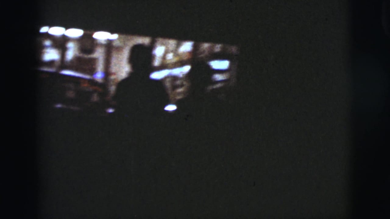 Dark car interior with a silhouetted person and bright windows beyond.