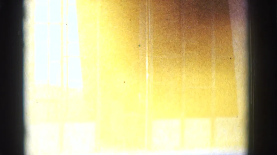 Overexposed 8mm frame from 1966 Clarkdale shows faint windows and wall surfaces washed in yellow-white light and film grain.