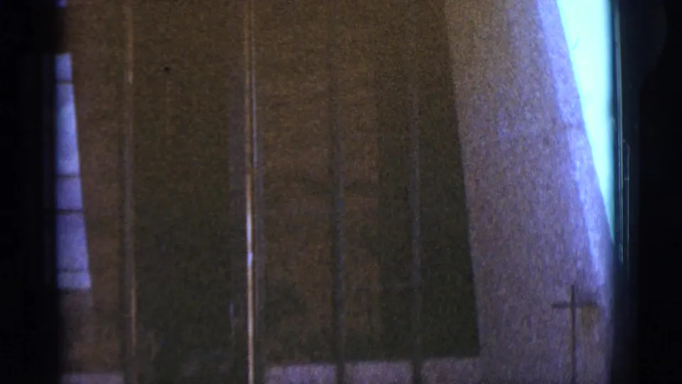 A late frame shows a dark wall or doorway area, narrow window slivers, and a pale edge within the color-shifted 1966 Clarkdale 8mm footage.