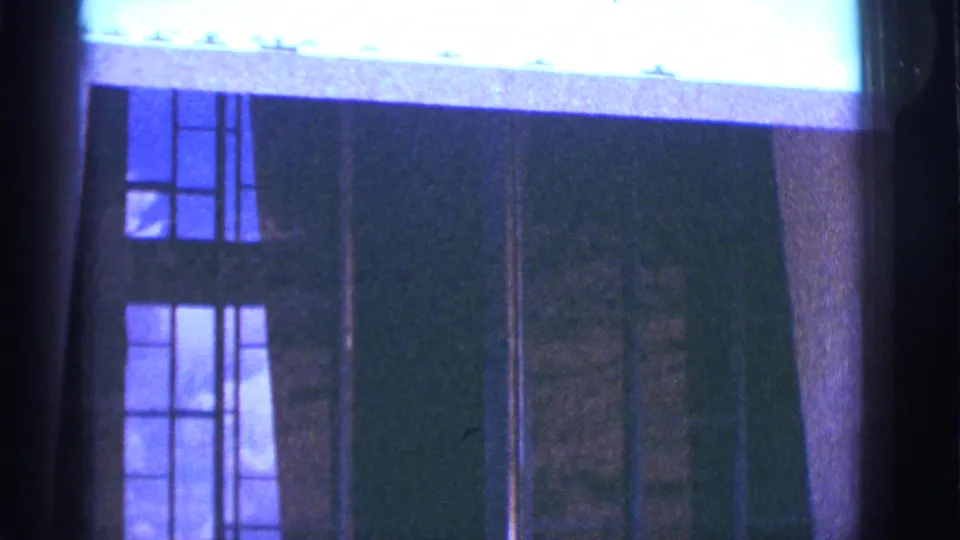 1966 Clarkdale, Arizona frame of tall dark-framed building windows below a bright overexposed roofline or sky area.