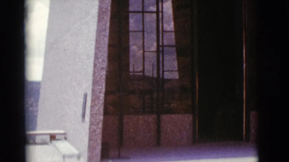 Clarkdale building exterior with tall windows, textured stone, and a small bench near the lower edge of the frame.