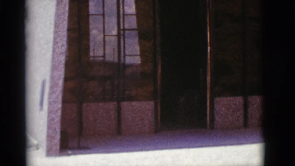 Lower part of a 1966 Clarkdale stone building exterior, with window panels and strong dark vertical framing.