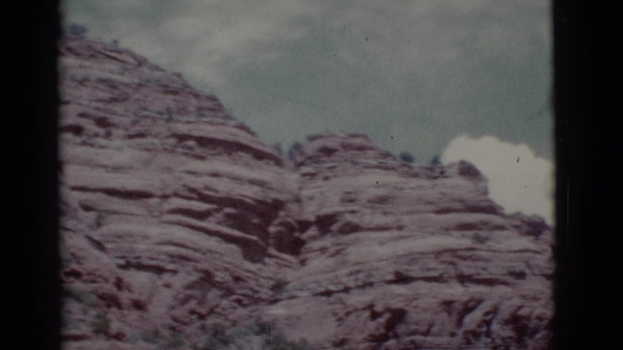 Red rock ridges and a narrow gap beneath a cloudy sky.