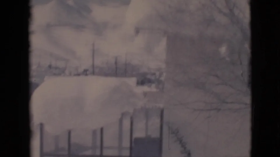Clarkdale, Arizona 1966 frame with a snow-laden roof or yard structure, fencing, and winter trees in soft 8mm color.