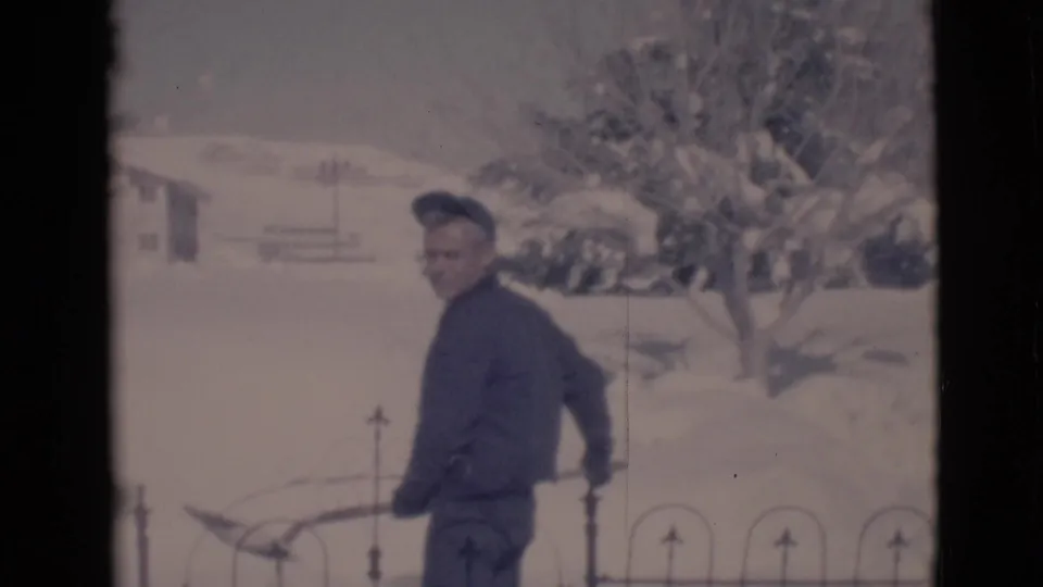 The youth pauses in profile with a shovel in a snowy Clarkdale yard, with a black fence and snow-covered trees behind him.