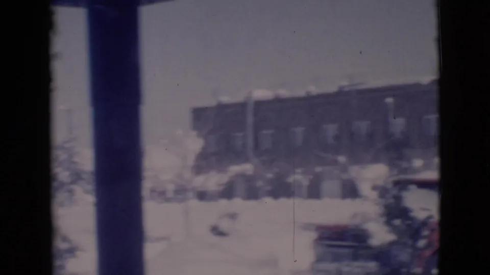 1966 Clarkdale, Arizona frame showing a brick building, parked cars, and heavy snow across the foreground.