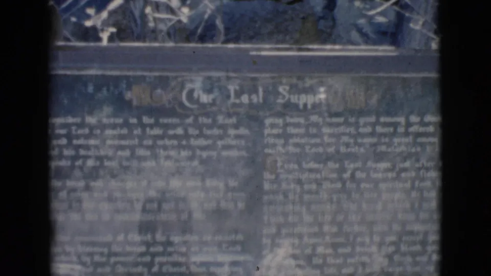 Final Clarkdale shrine frame showing The Last Supper plaque text in soft 8mm focus, with display material along the top edge.