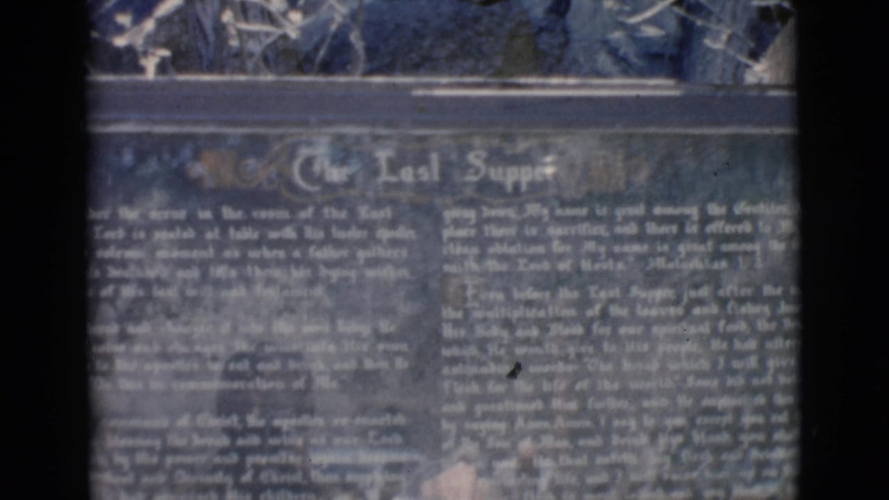 Close view of the Last Supper sign, with text softened by grain and blur.