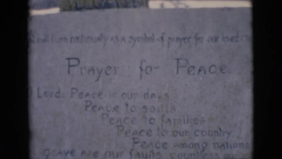 Soft 8mm frame from Clarkdale, Arizona showing the Prayer for Peace plaque below a white seated religious figure.