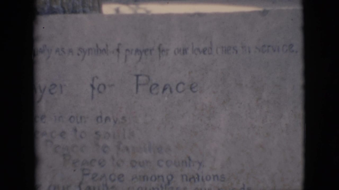 Close view of the same Prayer for Peace note with faint handwritten lines below.