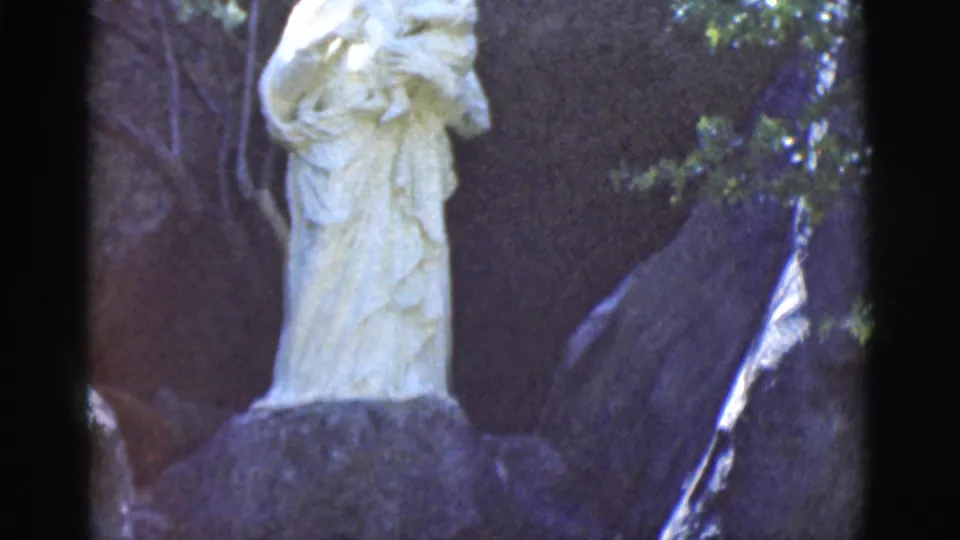 Late frame from the 1966 Clarkdale clip shows the statue lower in the 8mm frame, surrounded by dark rocks and greenery.