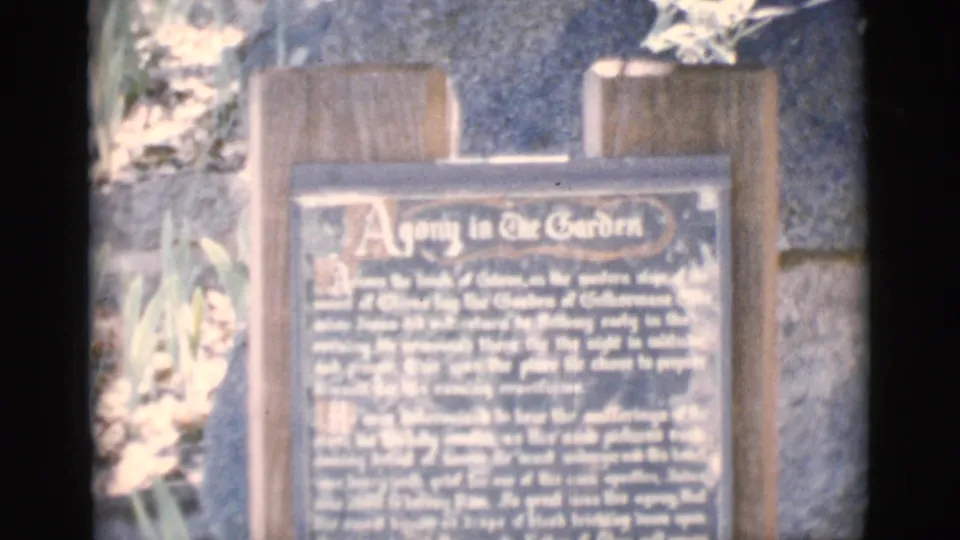 1966 Clarkdale, Arizona frame showing a wooden interpretive plaque titled Agony in the Garden, partly softened by exposure and focus.