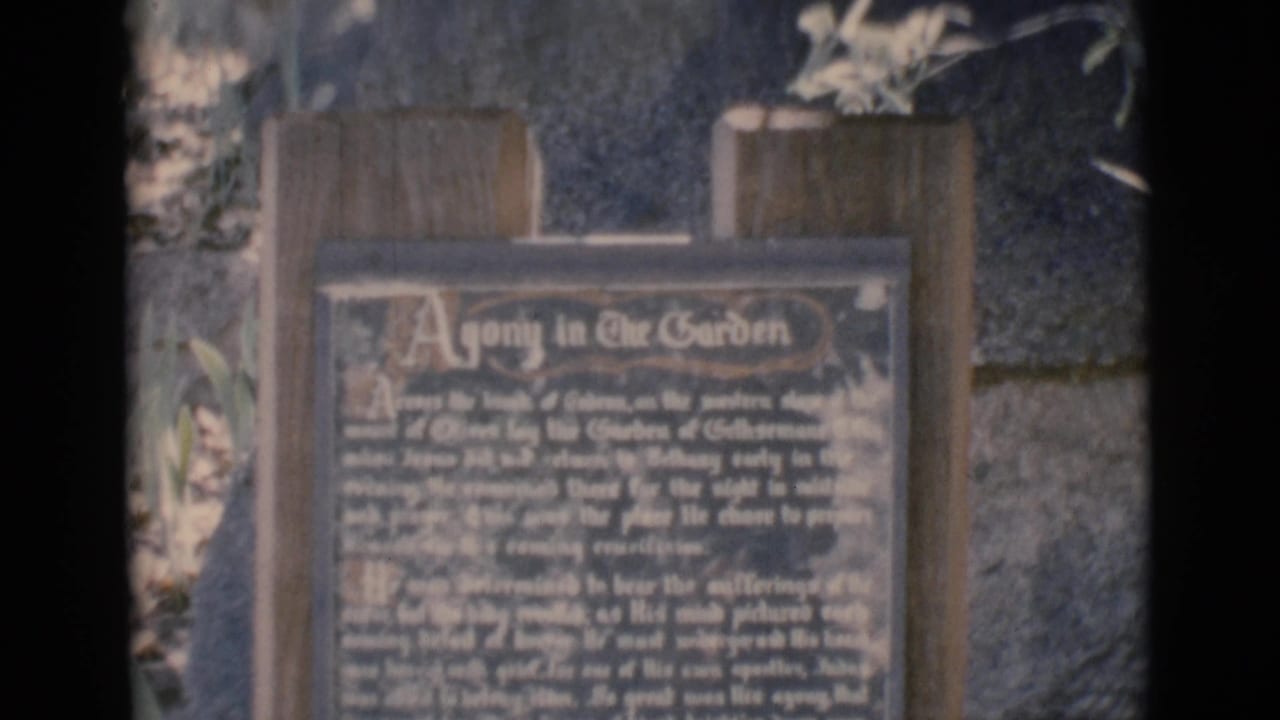 Agony in the Garden plaque seen in soft focus outdoors.